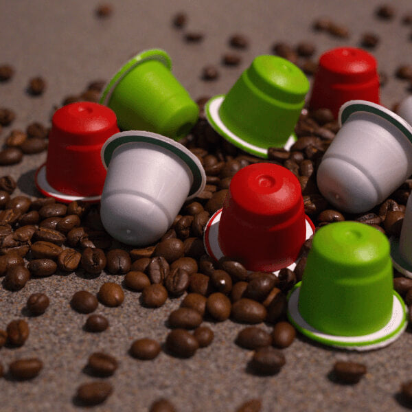 Coffee capsules on bench with beans